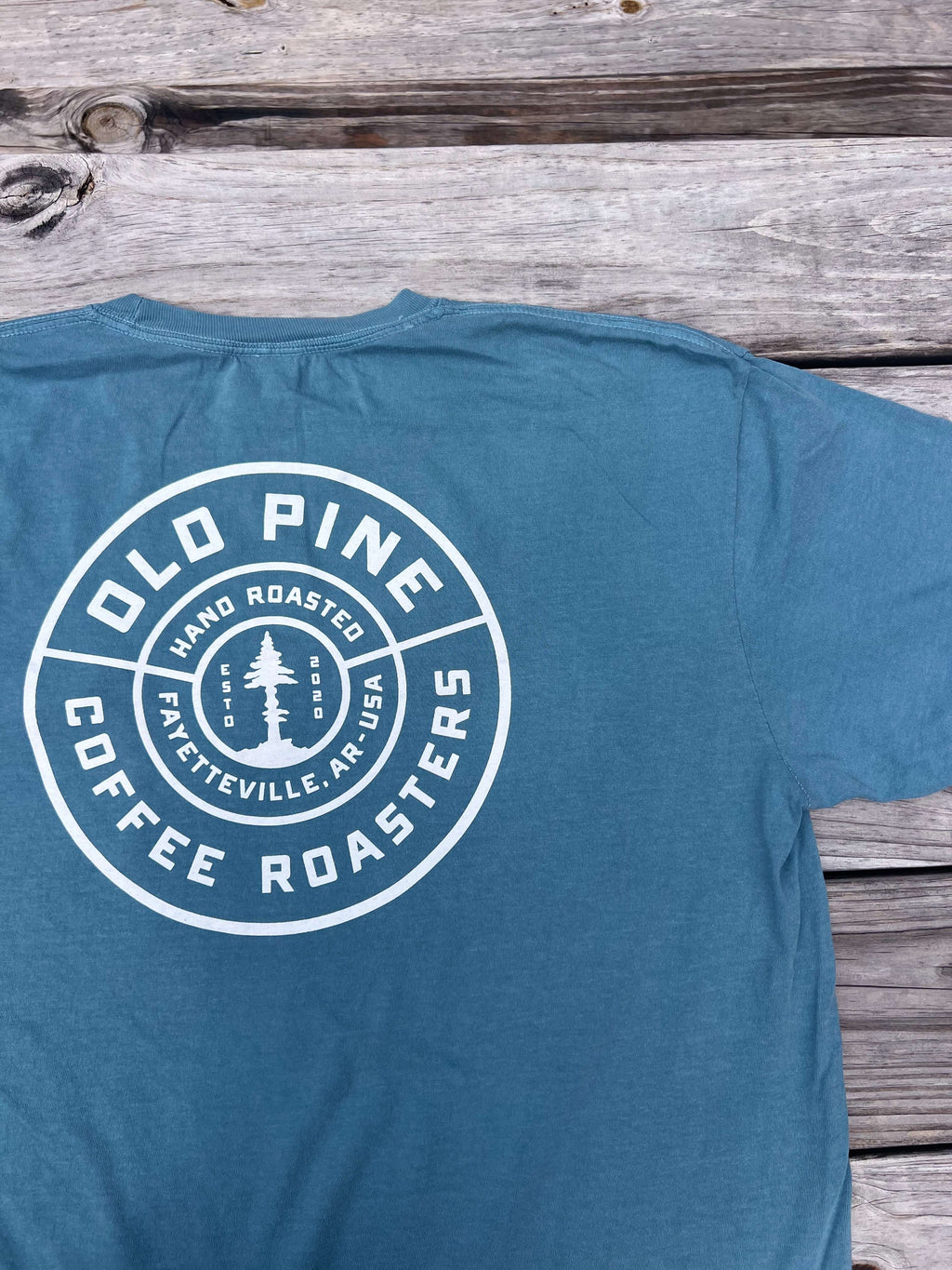 Blue t-shirt with Old Pine Coffee Roasters badge logo on back of shirt